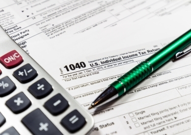 Tax Forms on Table with Pen and Calculator
